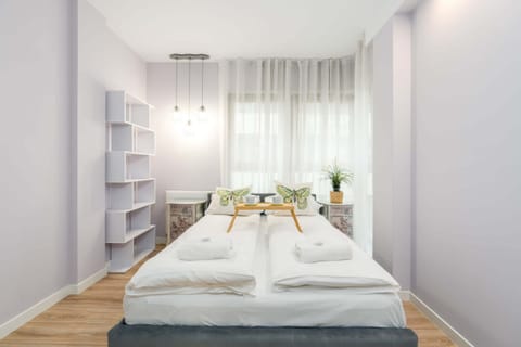 A serene bedroom with a comfortable double bed and soft white bedding.