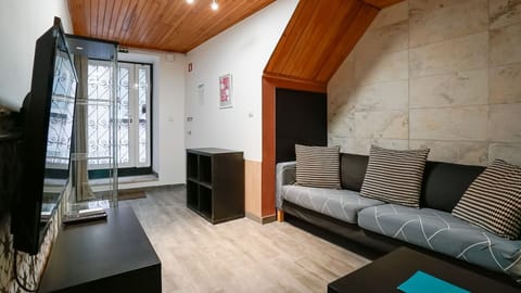 A cosy living room with warm wood details and a comfortable sofa, perfect for unwinding after a day exploring central Lisbon. #Chiado #LisbonStay #CozyLiving #CityBreak #portugal #pt #lisbon