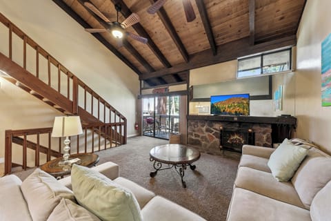 Relax in your spacious living room with exposed wood beams, stone fireplace, and comfortable seating perfect for cozy evenings together.