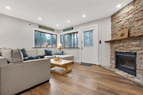 living room with stacked stone gas fireplace