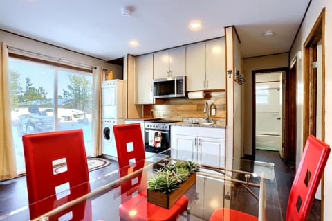- Sleek kitchen featuring granite countertops and stainless appliances
- Enjoy meals at the glass top dining table with vibrant red chairs and a succulent centerpiece
- Natural light pours in from sliding glass doors, revealing a snow dusted outdoor 