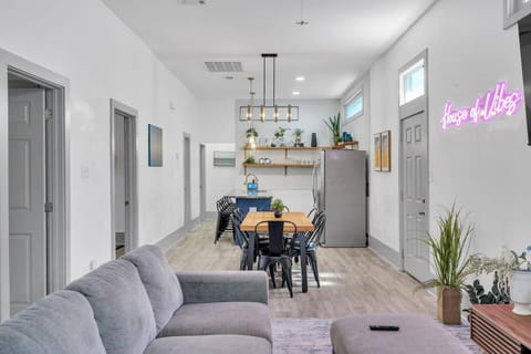 A perfect blend of modern and cozy! This open-concept space features sleek kitchen accents, a stylish dining area, and a comfy living room—topped off with a neon 'House of Vibes' sign for that extra touch of personality!