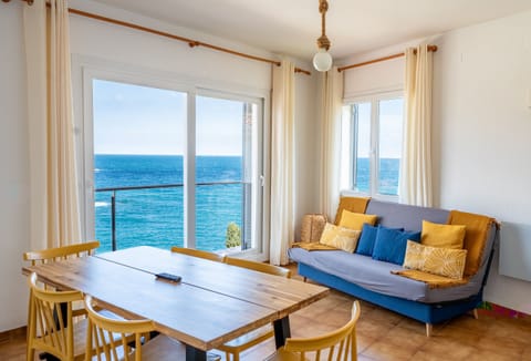 Living room on the first floor with unobstructed sea views and balcony access — the kind of view that makes a family holiday feel effortless from the moment you wake up.