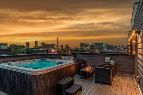 Private outdoor rooftop deck with stunning city views featuring a relaxing hot tub, firepit with outdoor furnishings, BBQ grill, and outdoor dining.