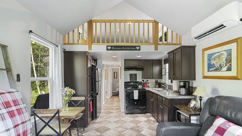 Open-concept cabin with loft, kitchen, and cozy living space