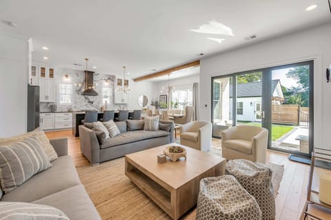 This angle showcases the inviting living room with its warm fireplace and wide glass doors that fill the space with natural light, a perfect setting for comfort and meaningful moments with loved ones.