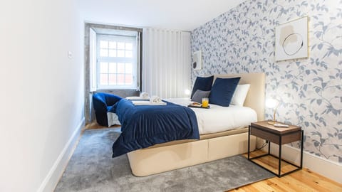 A modern bedroom in calming blue tones, creating a fresh yet relaxing atmosphere for restful nights in Porto.

#PortoStay #AirbnbPorto #ModernDesign #CozyBedroom