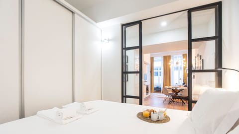 A modern bedroom with sleek glass doors, blending contemporary design with a bright and open feel.

#PortoStay #AirbnbPorto #ModernDesign #StylishLiving