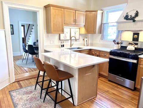 Kitchen fully stocked with dinnerware, glassware, and cooking pots/pans