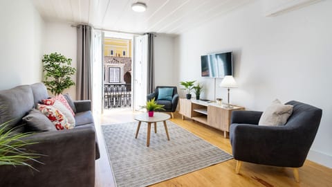 Relax in a sun-filled living space with cosy seating, elegant décor, and charming balcony doors that bring Lisbon’s atmosphere indoors. #LivingRoom #CityBreak #ModernComfort #LisbonStay #HolidayApartment #Portugal #PT #Lisbon