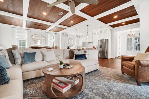 Relax in your elegant open-concept living space with stunning coffered wood ceilings and luxurious furnishings perfect for memorable gatherings.