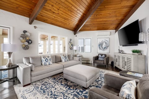 Bright living room w/ vaulted wood ceilings, plush sectional & large TV for cozy nights in.