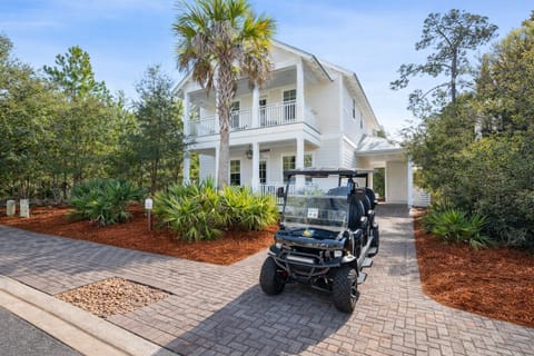 "A Wave From It All" a beautiful home, 1/2 mile from the beach with a 6 seat golf cart and heated pool access in a gated community.