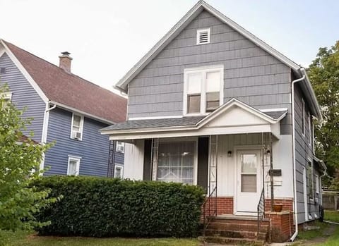 Front of house. Includes small patio with two chairs under front window.
