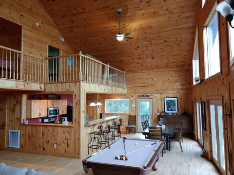 The great room has a pool table and dining area with extra seating at the bar.