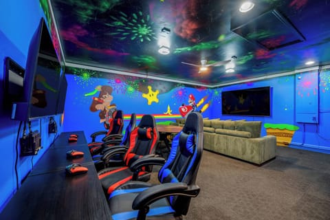 Converted garage game room with seating area and video games for entertaining