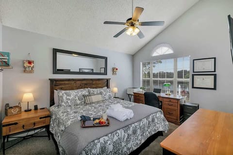 Beautiful and inviting master bedroom complete with a king bed, dual nightstands, en suite bathroom, closet, dresser, 50" TV (Netflix, Amazon Prime, Disney+, Local Stations) & desk overlooking the lake (printer).