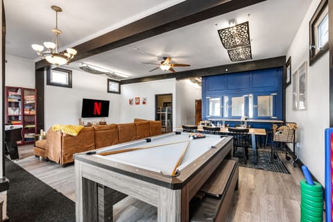 Entertainment Lounge: Enjoy games and streaming in a vibrant space, entertainment area featuring a pool table, cozy seating with a large TV for streaming, and a stylish dining space. Perfect for relaxing, playing games, or enjoying meals with friends