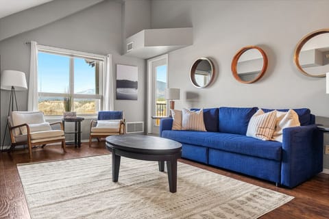 Living room with a smart TV, cozy seating and walkout access to the private, top-floor balcony.