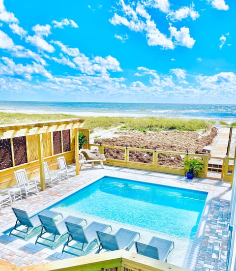 Your private pool deck overlooks pristine ocean waves, where crystal-clear waters meet endless blue skies for pure coastal bliss.
