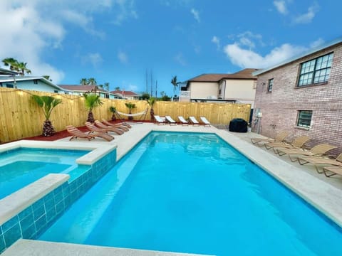 Large private swimming pool and spa with optional heating, surrounded by lounge seating