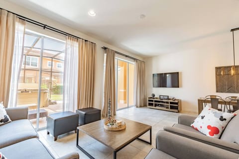 Enjoy the bright, airy living area filled with natural light, where soft gray upholstery and a stylish coffee table create a welcoming atmosphere, ideal for relaxation or casual gatherings with friends and family.