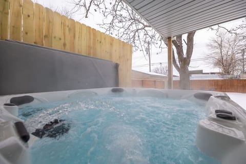 Relax in the privacy of a fenced backyard featuring a soothing hot tub, perfect for unwinding after a long day.