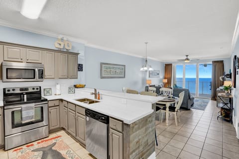 Your modern kitchen opens to the living area with stunning ocean views through floor-to-ceiling windows—perfect for morning coffee with endless blue horizons.