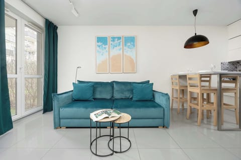 Living room with turquoise sofa, round coffee table and bright decorations.