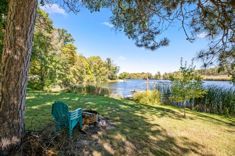 Outdoor firepit and chairs overlooking the lake in the spacious backyard. 