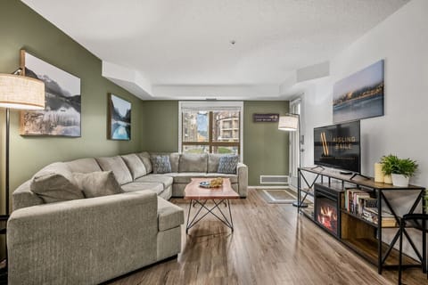Spacious living area with a Smart TV, electric fireplace, pull-out sleeper sofa and walkout access to the ground-floor patio space.