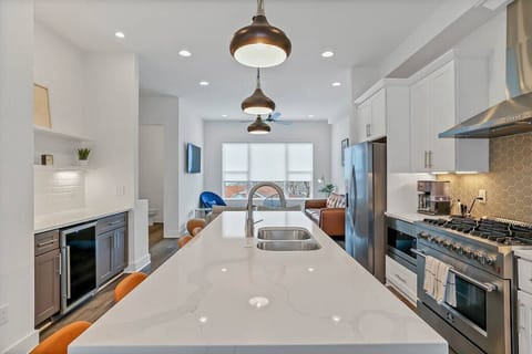 Kitchen island paired with wine bar fridge and stainless steel appliances.