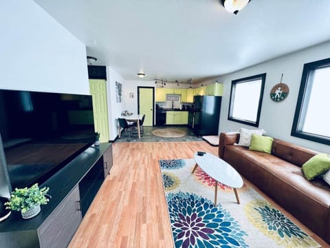 The living room includes a large flat screen smart tv and a comfortable leather sofa.