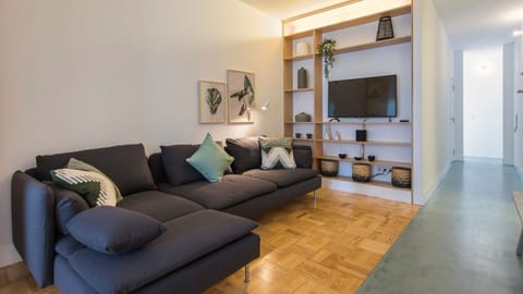 Relax and unwind in the cozy living area, featuring a comfortable sectional sofa perfect for movie nights or quiet evenings with a good book. The integrated shelving unit provides both style and functionality, keeping your space tidy. #LivingRoom #Comfort