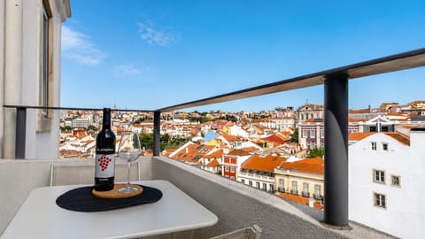 Unwind on your private balcony with a glass of local wine, taking in the breathtaking panorama of Lisbon's colorful rooftops. This inviting outdoor space is perfect for enjoying morning coffee or an evening aperitif with a view. #PrivateBalcony #CityPanor