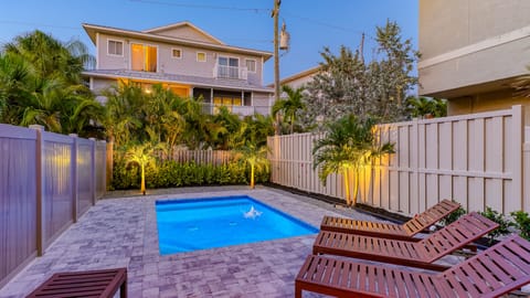Crystal Sands pool and patio at twilight with landscape lights. Making evening dips a pure tropical bliss.