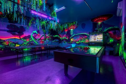 Step into a neon-lit jungle and rack 'em up at the pool table under the glow.