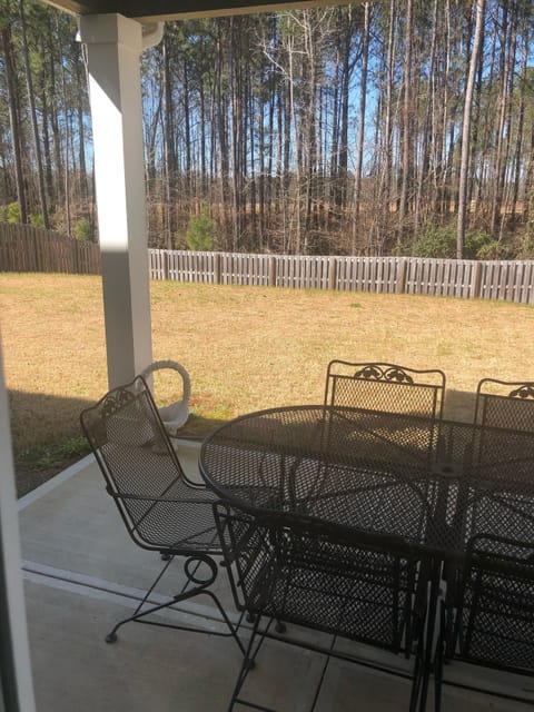 Covered backyard with bar-b-cue grill and patio furniture.