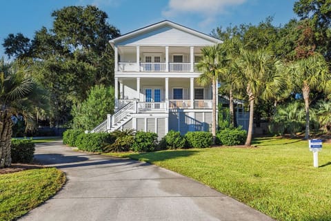 Charming two-story coastal home with double porches and tropical landscaping, set in a peaceful neighborhood setting.