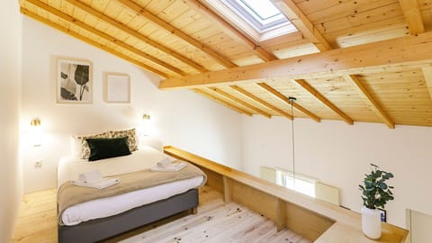 Wake up to gentle light in this inviting upstairs bedroom, where the charming sloped ceiling and warm wood accents create a serene atmosphere. This elevated retreat offers a private, peaceful haven for a restful night's sleep.