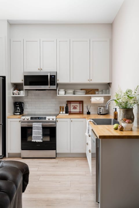 2-South kitchen with light grey cabinets, stainless appliances, and butcher block counters.
