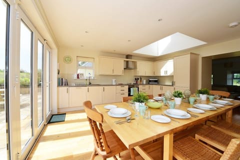 Hawthorn House - bright, spacious kitchen with large dining table and doors out to the patio and garden