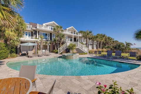 Expansive private pool surrounded by lush palms and coastal elegance