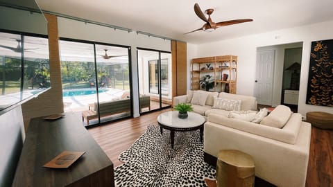 Living room looking out to the pool and screened lanai w/ 2 sliding glass doors