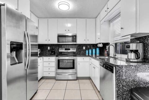 Cook with ease in our modern, fully equipped kitchen featuring stainless steel appliances and ample granite counter space. A clean, bright spot perfect for preparing vacation meals and morning coffee!