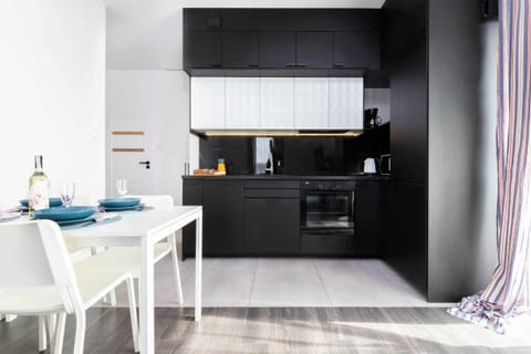 Another look at the kitchen, showcasing dark and white cabinets, modern appliances, and a clean aesthetic.