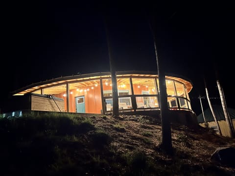 Glowing against the night sky, Spicewood Yurt is a stunning sight perched on the hillside, warm light pouring from every window and string lights wrapping the deck in a welcoming glow.
