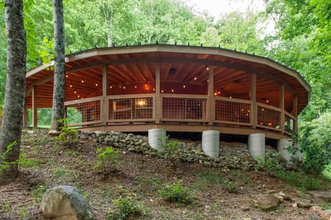 Perched above a stone foundation and wrapped in a sweeping circular deck strung with lights, Spicewood Yurt is unlike anything you've ever stayed in — a one-of-a-kind retreat rising out of the Smoky Mountain forest.