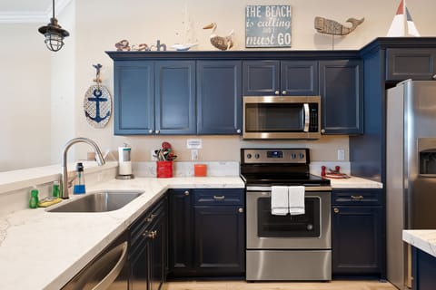 Fully stocked kitchen has stainless steel appliances and plenty of counter space for preparing your meals.