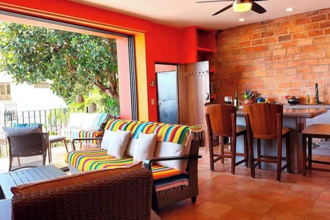 The open design living space and kitchen opens onto the large private balcony overlooking the pool below and ocean in the distance.